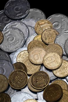 Ukrainian coins isolated on black background. Close-up view. Coins are located below the center of frame. A conceptual image.