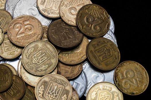 Ukrainian coins isolated on black background. Close-up view. Coins are located at the left side of frame. A conceptual image.