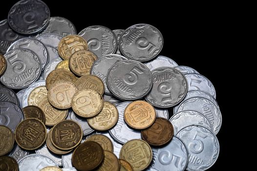 Ukrainian coins isolated on black background. Close-up view. Coins are located at the left side of frame. A conceptual image.
