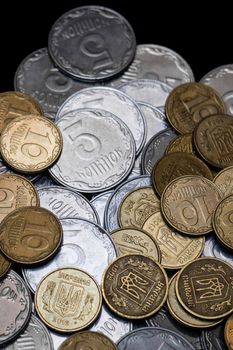 Ukrainian coins isolated on black background. Close-up view. Coins are located below the center of frame. A conceptual image.