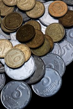 Ukrainian coins isolated on black background. Close-up view. Coins are located above the center of frame. A conceptual image.