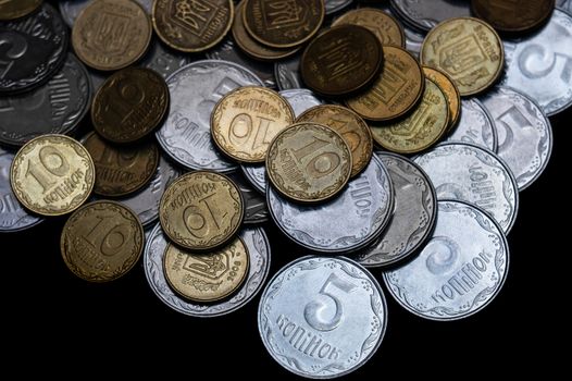 Ukrainian coins isolated on black background. Close-up view. Coins are located above the center of frame. A conceptual image.