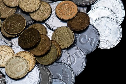 Ukrainian coins isolated on black background. Close-up view. Coins are located at the left side of frame. A conceptual image.