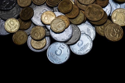 Ukrainian coins isolated on black background. Close-up view. Coins are located above the center of frame. A conceptual image.