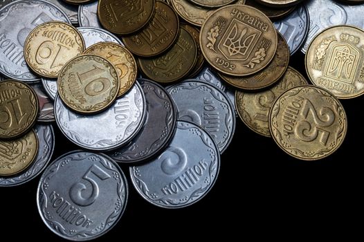 Ukrainian coins isolated on black background. Close-up view. Coins are located above the center of frame. A conceptual image.