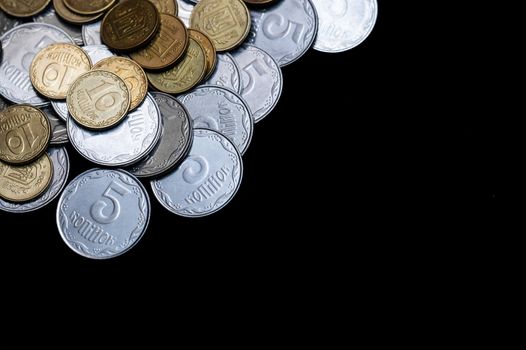 Ukrainian coins isolated on black background. Close-up view. Coins are located left-upper corner of image. A conceptual image.