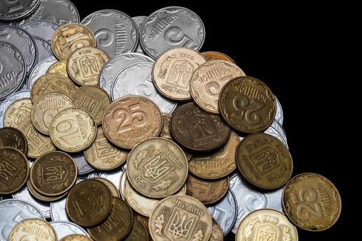 Ukrainian coins isolated on black background. Close-up view. Coins are located at the left side of frame. A conceptual image.