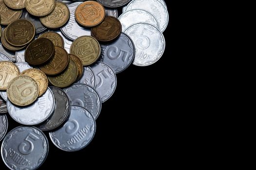 Ukrainian coins isolated on black background. Close-up view. Coins are located at the left side of frame. A conceptual image.