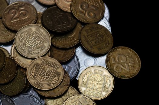 Ukrainian coins isolated on black background. Close-up view. Coins are located at the left side of frame. A conceptual image.