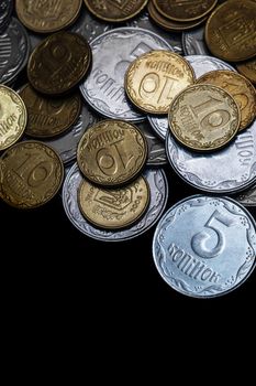 Ukrainian coins isolated on black background. Close-up view. Coins are located above the center of frame. A conceptual image.