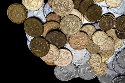 Ukrainian coins isolated on black background. Close-up view. Coins are located at the right side of frame. A conceptual image.