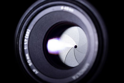 Lens aperture low light photo. Aperture blades is clean. Stock photo with blurred foreground. Isolated on black background.