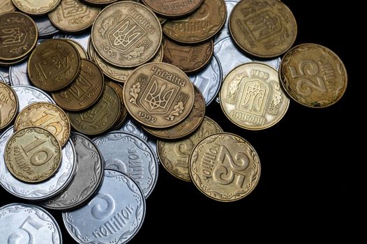 Ukrainian coins isolated on black background. Close-up view. Coins are located above the left side of frame. A conceptual image.