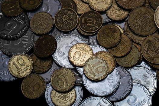 Ukrainian coins isolated on black background. Close-up view. Coins are located above the center of frame. A conceptual image.