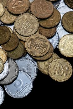 Ukrainian coins isolated on black background. Close-up view. Coins are located above the center of frame. A conceptual image.