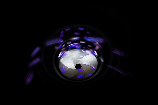 Lens aperture low light photo closeup. Blue traces on glass. Aperture blades is clean. Stock photo isolated on black background.