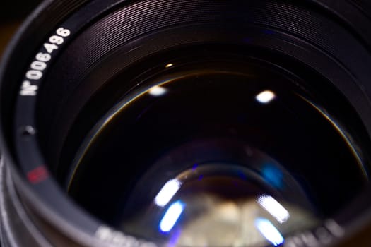 Lens glass low light photo closeup. Blue traces on glass. Aperture is defocused and blurred.