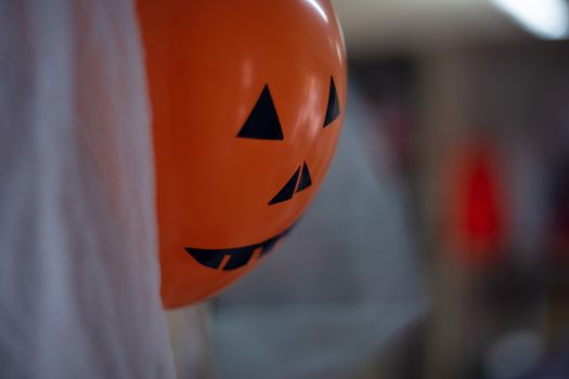 Orange scary halloween air ball with eyes, nose and mouth. Halloween decoration.