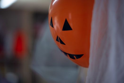 Orange scary halloween air ball with eyes, nose and mouth. Halloween decoration.