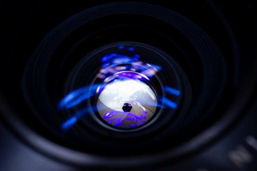Lens aperture low light photo closeup. Blue traces on glass. Aperture blades is clean. Stock photo isolated on black background.