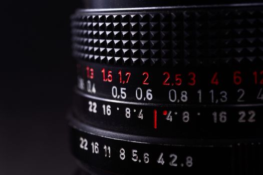 Vintage lens scale signs closeup. Stock photo with blurred gray background.
