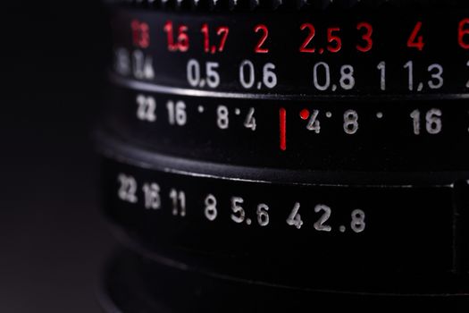 Vintage lens scale signs closeup. Stock photo with blurred gray background.