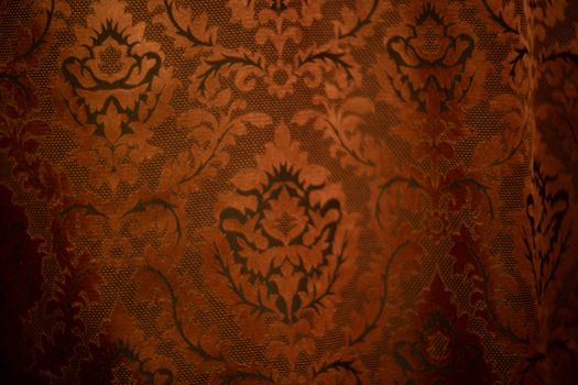 Expensive dark orange home curtains with a very beautiful frilly pattern. Texture shot. Good background or wallpapers.