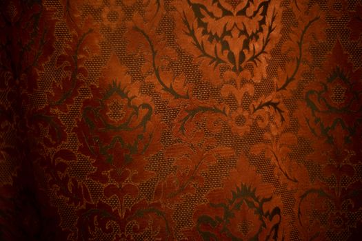Expensive dark orange home curtains with a very beautiful frilly pattern. Texture shot. Good background or wallpapers.
