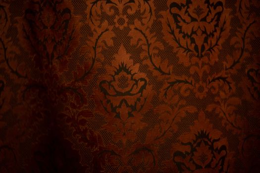 Expensive dark orange home curtains with a very beautiful frilly pattern. Texture shot. Good background or wallpapers.