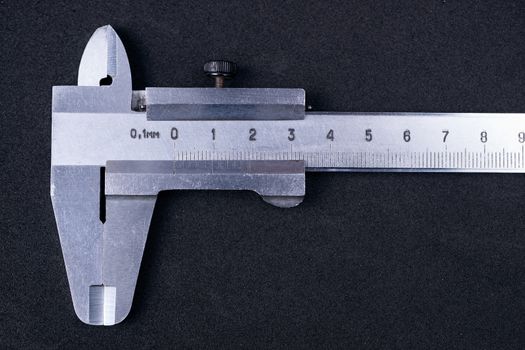 Vintage steel caliper tool closeup. Caliper in very good condition. Scale in metric units, milimeter step. Stock photo isolated on gray background.