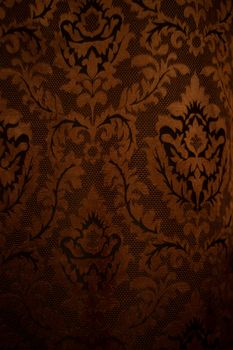Expensive dark orange home curtains with a very beautiful frilly pattern. Texture shot. Good background or wallpapers.
