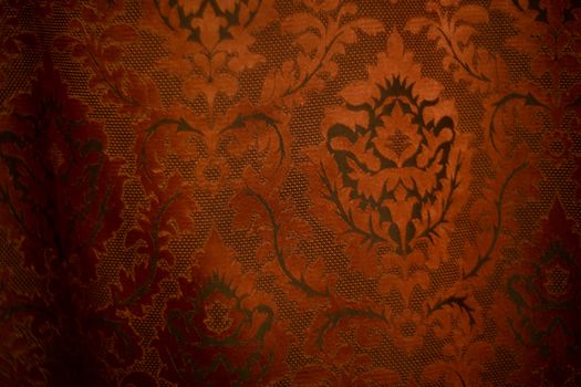 Expensive dark orange home curtains with a very beautiful frilly pattern. Texture shot. Good background or wallpapers.