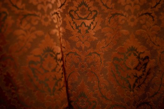 Expensive dark orange home curtains with a very beautiful frilly pattern. Texture shot. Good background or wallpapers.