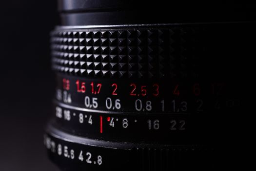 Vintage lens scale signs closeup. Stock photo with blurred gray background.