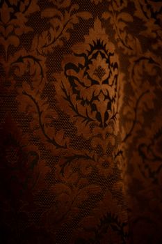 Expensive dark orange home curtains with a very beautiful frilly pattern. Texture shot. Good background or wallpapers.