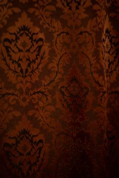 Expensive dark orange home curtains with a very beautiful frilly pattern. Texture shot. Good background or wallpapers.