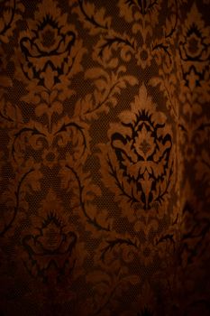 Expensive dark orange home curtains with a very beautiful frilly pattern. Texture shot. Good background or wallpapers.