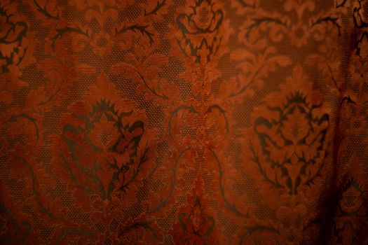 Expensive dark orange home curtains with a very beautiful frilly pattern. Texture shot. Good background or wallpapers.
