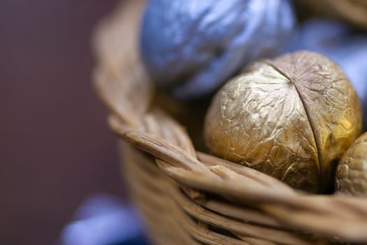 Silver and golden holiday candy nuts in a wicker basket.