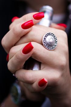 Caucasian woman with red nails manicure and antique ring on finger holds small vape. Smoking alternative vay. Life without cigarettes. Woman-vaper. Small e-cigarette.