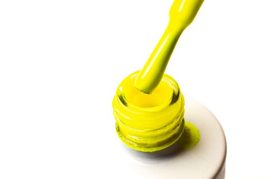 Varnish brush with yellow gel varnish isolated on white background.
