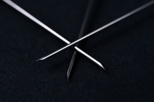 Old rare metallic medical needles isolated on gray background. Needles new and clean. Top view. Sharp needle tips and defocused background.