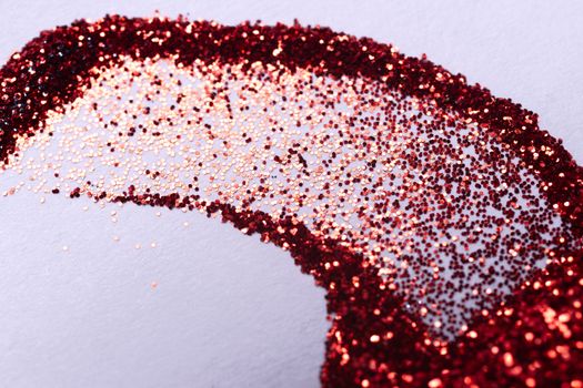A hue red nail gritter for manicure. Red glitter shining on daylight. Stock photo isolated on white background. Varnish topping.