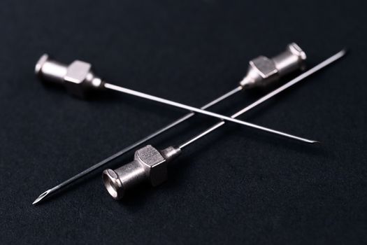 Old rare metallic medical needles isolated on gray background. Needles new and clean.