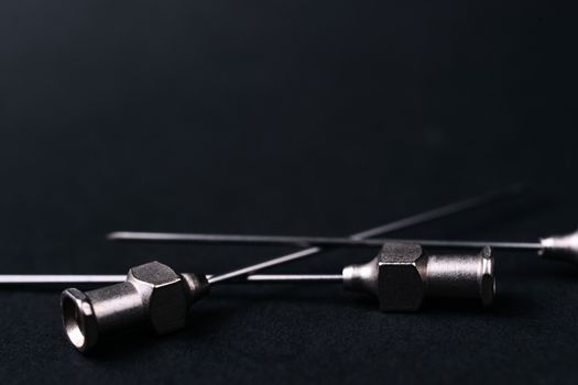 Old rare metallic medical needles isolated on gray background. Needles new and clean. Top view. Sharp needle tips and full metal body.