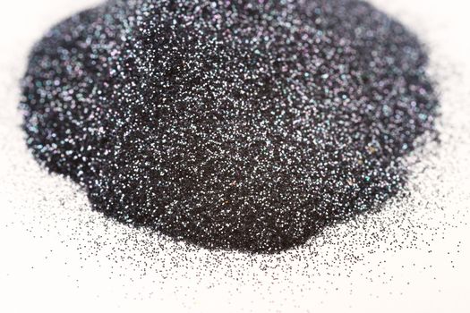 A bunch of silver blue nail gritter for manicure. Gray tone glitter shining on daylight. Stock photo isolated on white background. Varnish topping on paper.