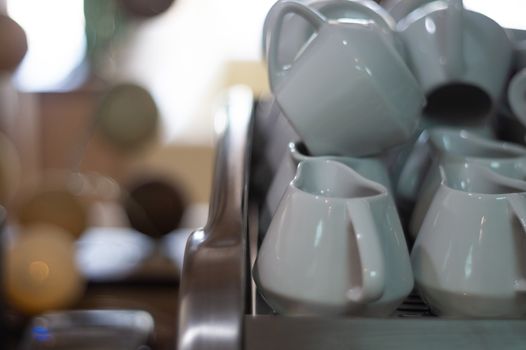 A lot of creamers on coffee machine in cafe