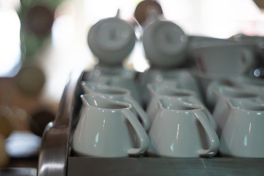A lot of creamers on coffee machine in cafe