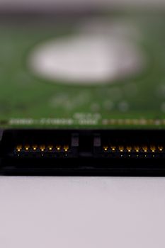 2.5mm laptop HDD on white blurred background. A lot of space on photo is defocused or have soft focus.