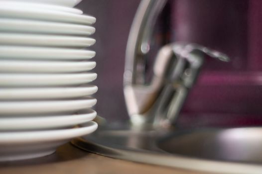 A lot of clean dish on table near sink in cafe. Close-up view